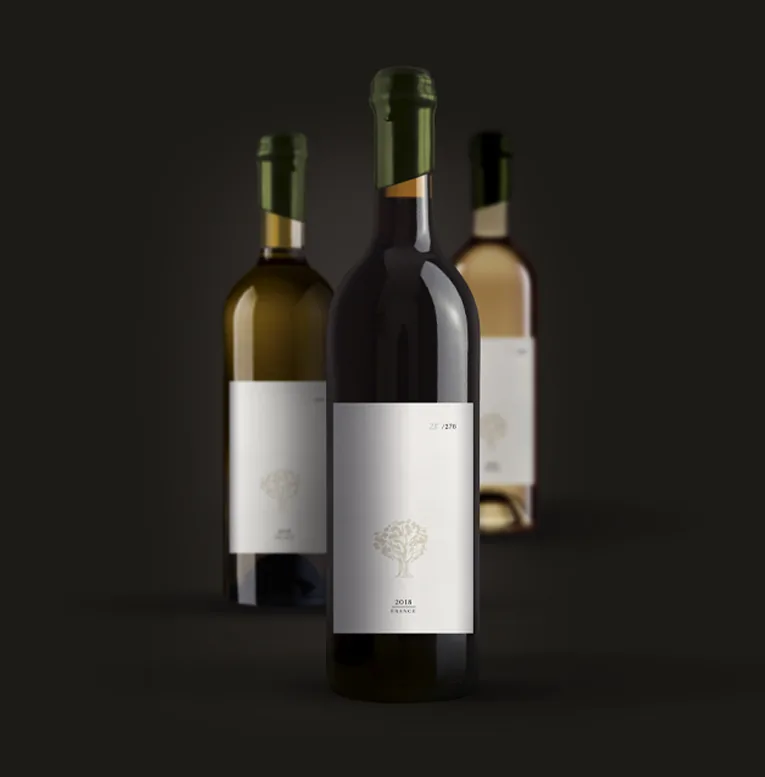 Trois bouteilles du domaine dans la pénombre du chai